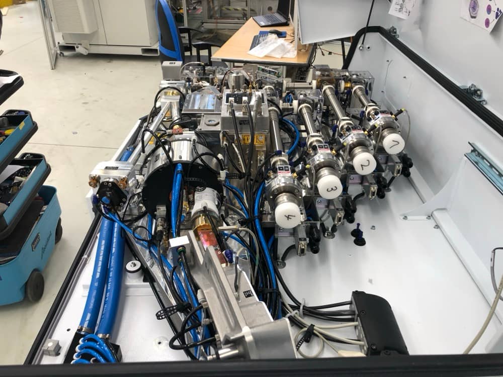 Detailní pohled na pneumatické rozvody a ventily stroje.